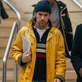 Project Hail Mary Ryan Gosling Yellow Coat worn by a Rylad Grace with a blue beanie and striped sweater while walking outdoors.